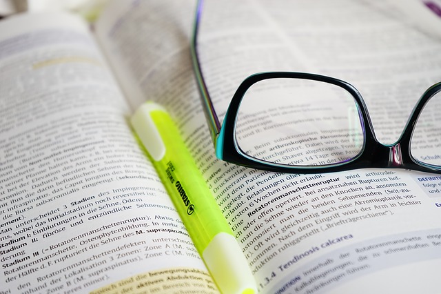 učebnice, brýle a propiska